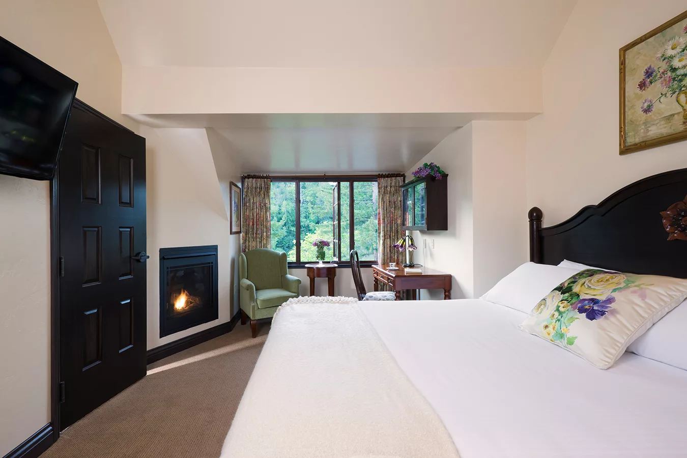 banner image is of Bedroom with fireplace and forest view at Benbow Historic Inn